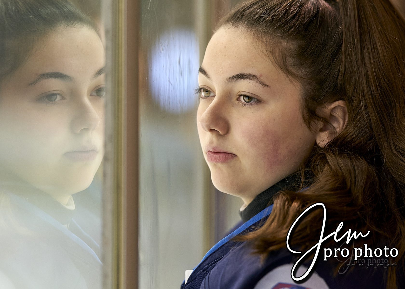 Jeune fille au regard sérieux, reflet dans une vitre